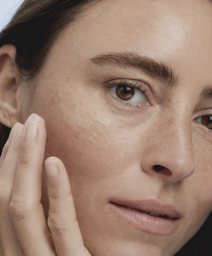 Close-up of a woman applying Kakadu Clean Cleansing Gel to her cheek, showcasing clean beauty and natural skincare with a focus on gentle, effective cleansing.