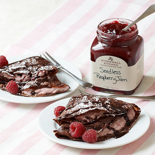chocolate crepes filled with raspberry mousse made with stonewall kitchen seedless raspberry jam on a plate with fresh raspberries for garnish
